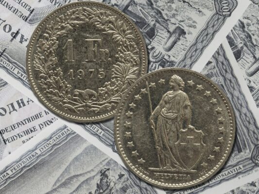 Vintage Swiss franks coin isolated on paper money background