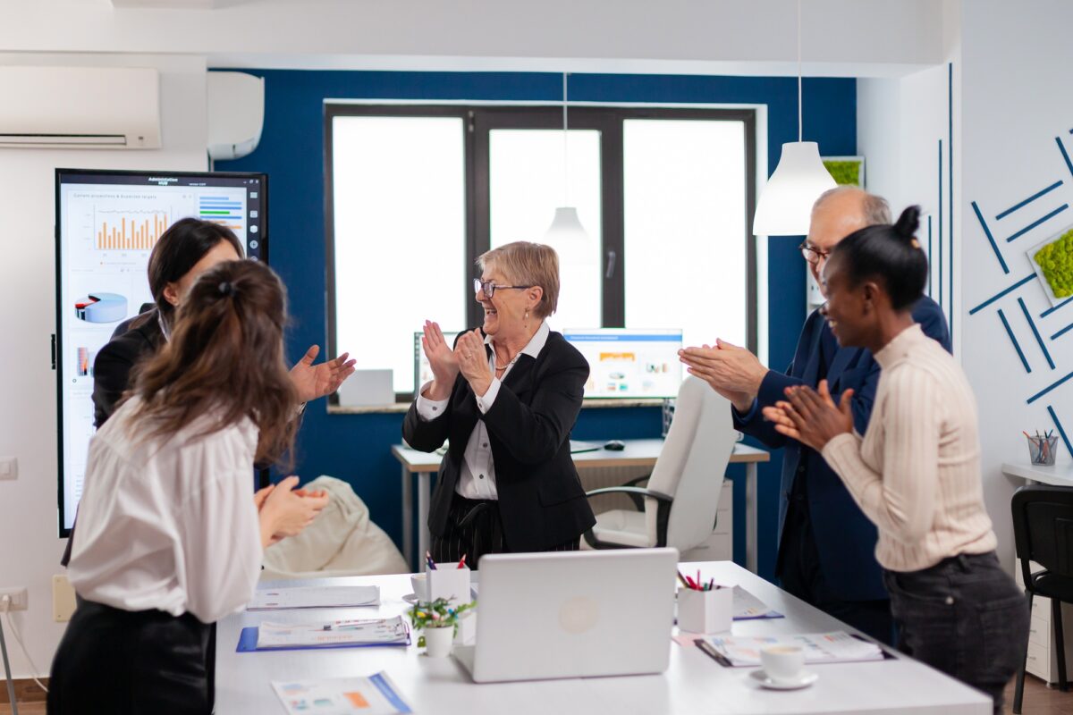 Happy excited diverse team of financial team in conference room