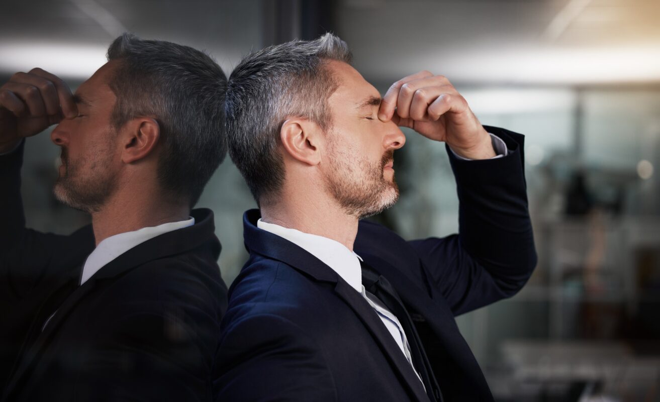 Im ready for this day to end. Shot of a businessman looking stressed while standing in his office.